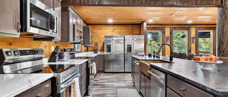 A modern kitchen with stainless steel appliances, wooden cabinetry, and a large island.