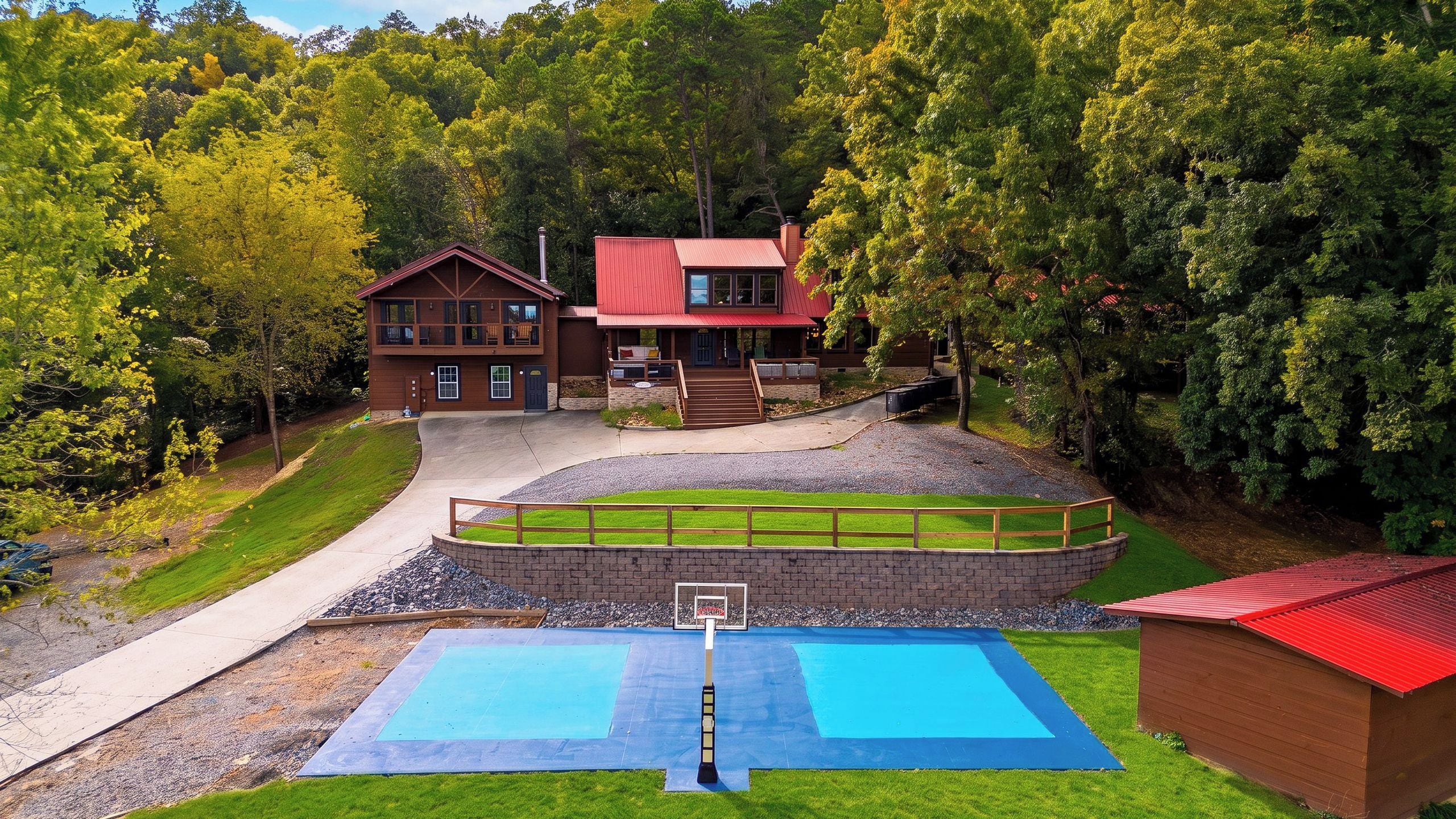 A two-story wooden cabin with a red roof, a basketball court, and a small pool.
