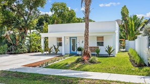 A modern single-story house with a white exterior, a blue door, and a small front porch. - Al Mare by Avantstay Private Pool + Firepit + Beach Gear Mass Arts District, Near Beach (Fort Lauderdale)