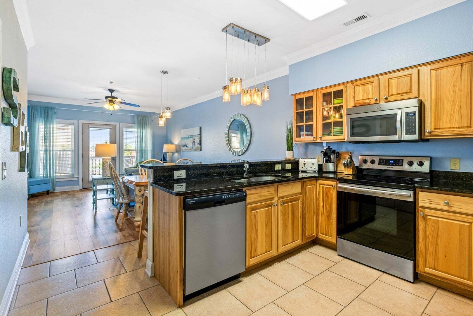 A modern kitchen with wooden cabinets, stainless steel appliances, and a central island.