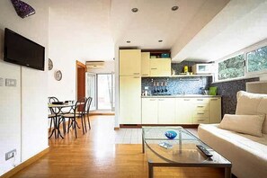 A modern kitchen with a dining area, a sofa, and a TV. - Next to the Olympic Stadium and the Milvio Bridge (Roma)