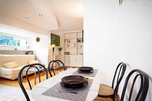 A dining area with a table set for two, chairs, a bookshelf, and a window with a view. - Next to the Olympic Stadium and the Milvio Bridge (Roma)