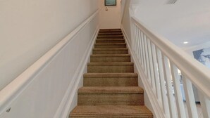 Eine Treppe mit Teppichstufen und weißen Geländern.