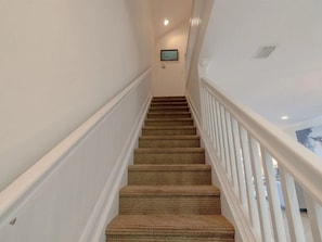 Eine Treppe mit Teppichstufen und weißen Geländern.