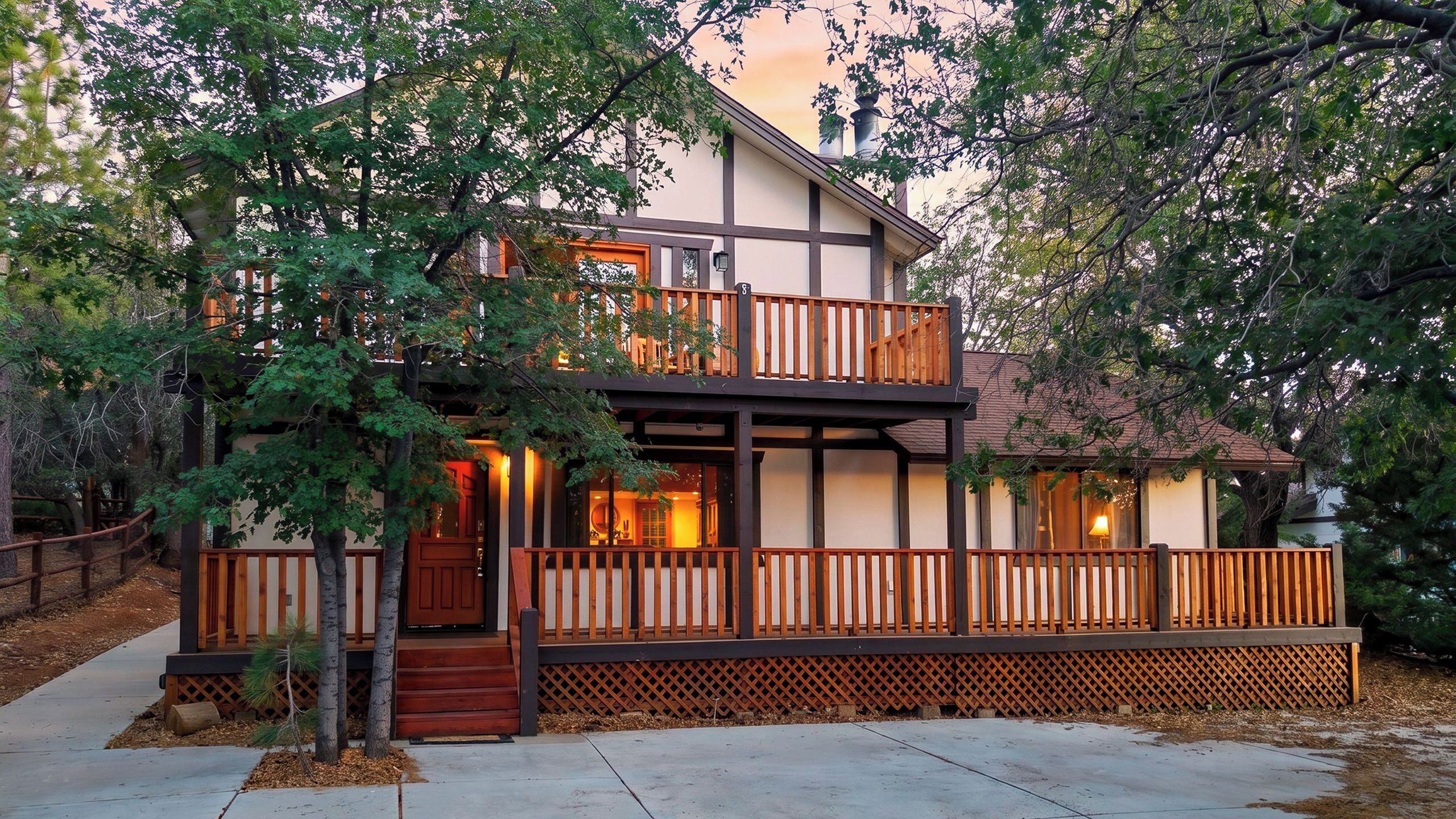 A two-story house with a wooden deck and a covered porch.
