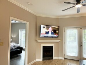 A living room with a fireplace, a television mounted above it, and a ceiling fan. - Sweet Retreat - Unit 5206 - FREE Attraction Ticket with EACH night Stay Including Dollywood (Pigeon Forge)