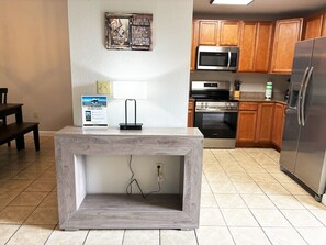 A kitchen with wooden cabinets, a stainless steel refrigerator, a microwave, and a built-in wooden island with a power outlet. - Sweet Retreat - Unit 5206 - FREE Attraction Ticket with EACH night Stay Including Dollywood (Pigeon Forge)