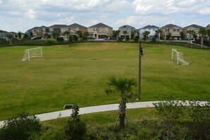 A residential area with houses, a soccer field, and a pathway. - Disney Dreams Luxury Home With Private Water Park (Kissimmee)