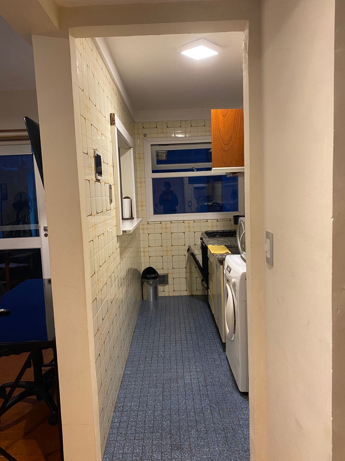 A compact kitchen with a washing machine, a sink, and a window.