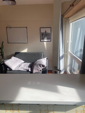 A room with a bed, a framed picture on the wall, and a window with curtains. - Studio apartment in the Guemes-Aldrey area (Mar del Plata)