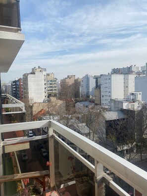 A high-rise building with multiple floors, large windows, and a view of a cityscape with various buildings. - Studio apartment in the Guemes-Aldrey area (Mar del Plata)