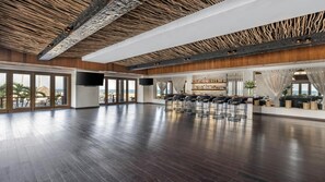 Um espaço amplo e interno com bar, assentos e grandes janelas com vista.