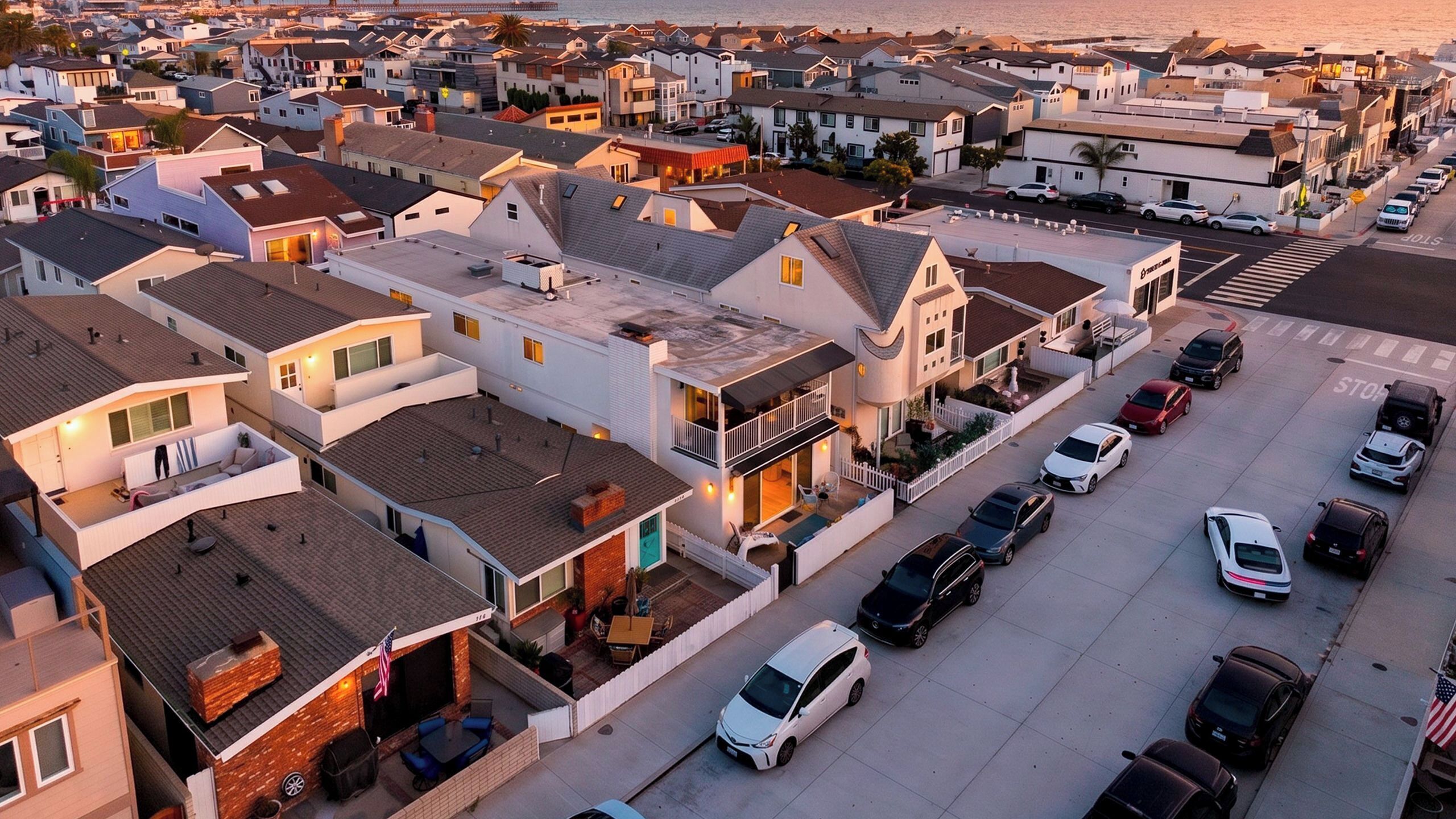 A residential area with houses, a street, and parked cars.