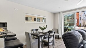 Una cocina moderna con microondas integrado y una zona de comedor con una mesa dispuesta para dos.