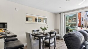 Een moderne keuken met een ingebouwde magnetron en een eethoek met een tafel gedekt voor twee personen.