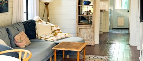 A living room with a sofa, a coffee table, a rug, and a cabinet.