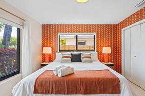 Une chambre d’hôtel avec un grand lit, deux tables de chevet avec des lampes, une fenêtre donnant sur l’extérieur et une armoire.