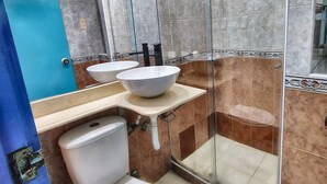 Casa de banho com duas pias, sanita e chuveiro.