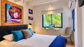 A bedroom with a bed, a desk with a laptop, a chair, and a window with a view of trees. - Apto Centro Histórico Balcón (Santa Marta)