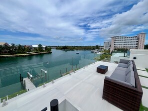 Un hôtel situé au bord de l’eau, doté d’un quai, d’un espace de détente avec des sièges et offrant une vue sur le port de plaisance.