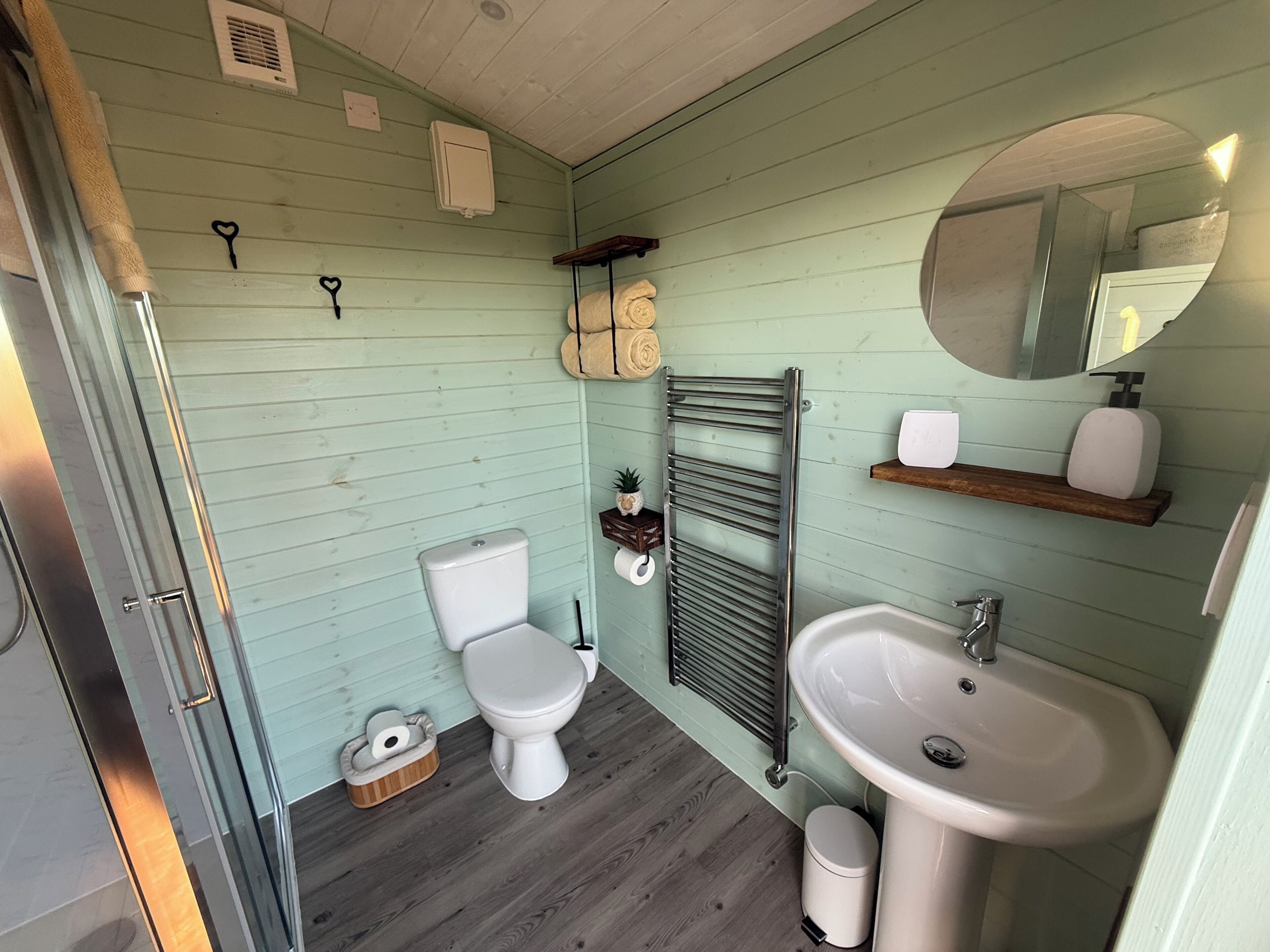 A compact bathroom with a toilet, sink, and a towel rack.