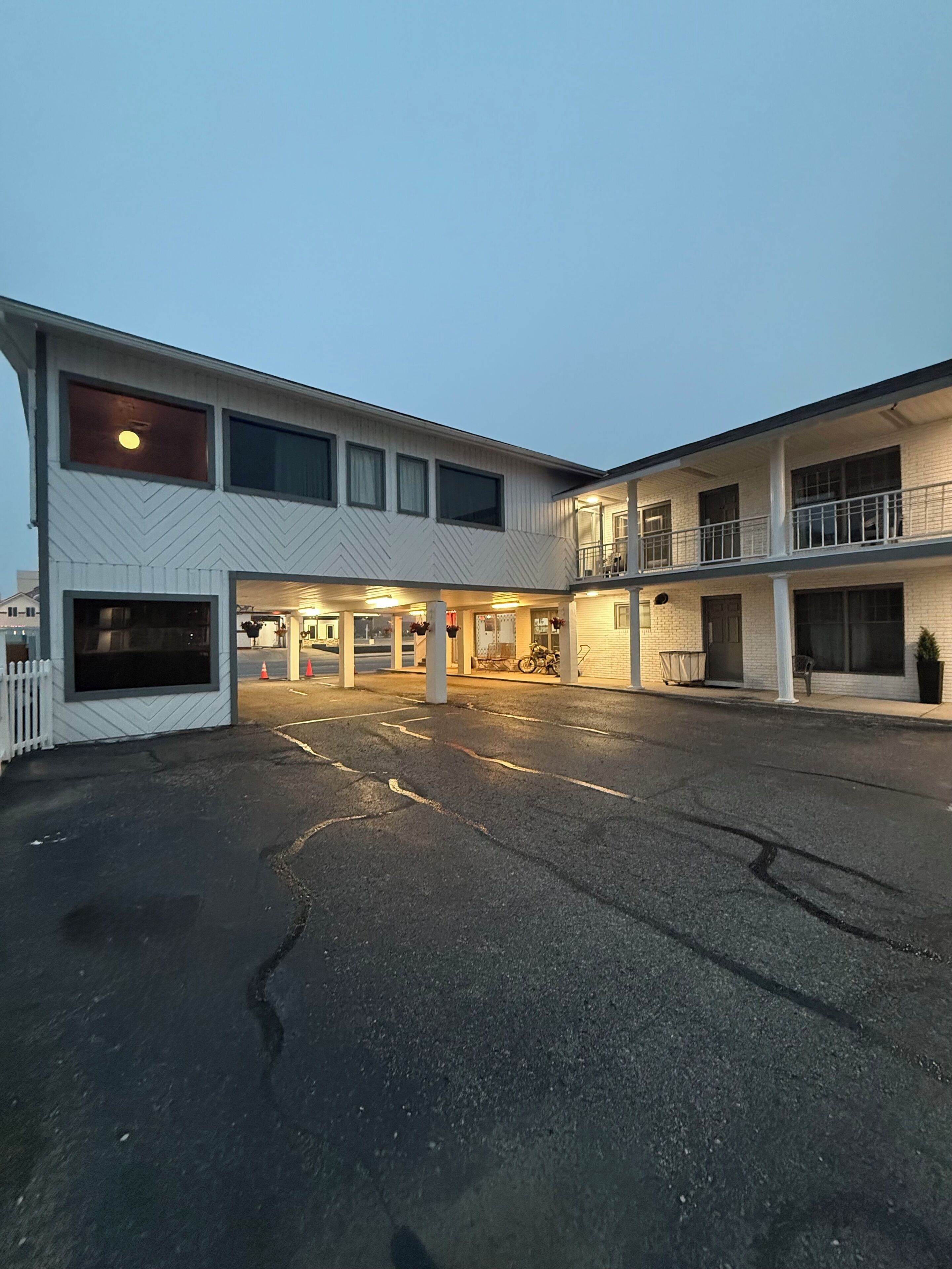 A two-story building with a parking lot in front.
