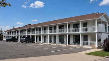 A two-story motel with a parking lot and a clear blue sky.