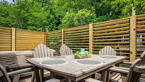 An outdoor patio area with a round table, four chairs, and a wooden fence. - Historic Hodge House|2BD•2BA|King Beds| Sleeps 6 (Banner Elk)