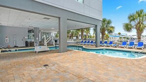 A pool area with a lifeguard stand, lounge chairs, and a view of the ocean. - Waterfront Condo | Harbourgate Marina Views (North Myrtle Beach)