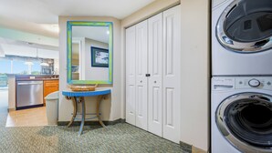 A laundry room with a washing machine, a mirror, and a door. - Waterfront Condo | Harbourgate Marina Views (North Myrtle Beach)