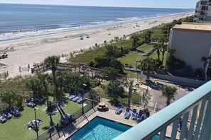Een resort met een zwembad, toegang tot het strand en uitzicht op de oceaan.