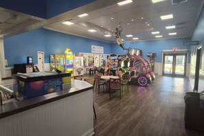 Een kinderspeelruimte met zandspellen, een automaat en een display met autootjes.
