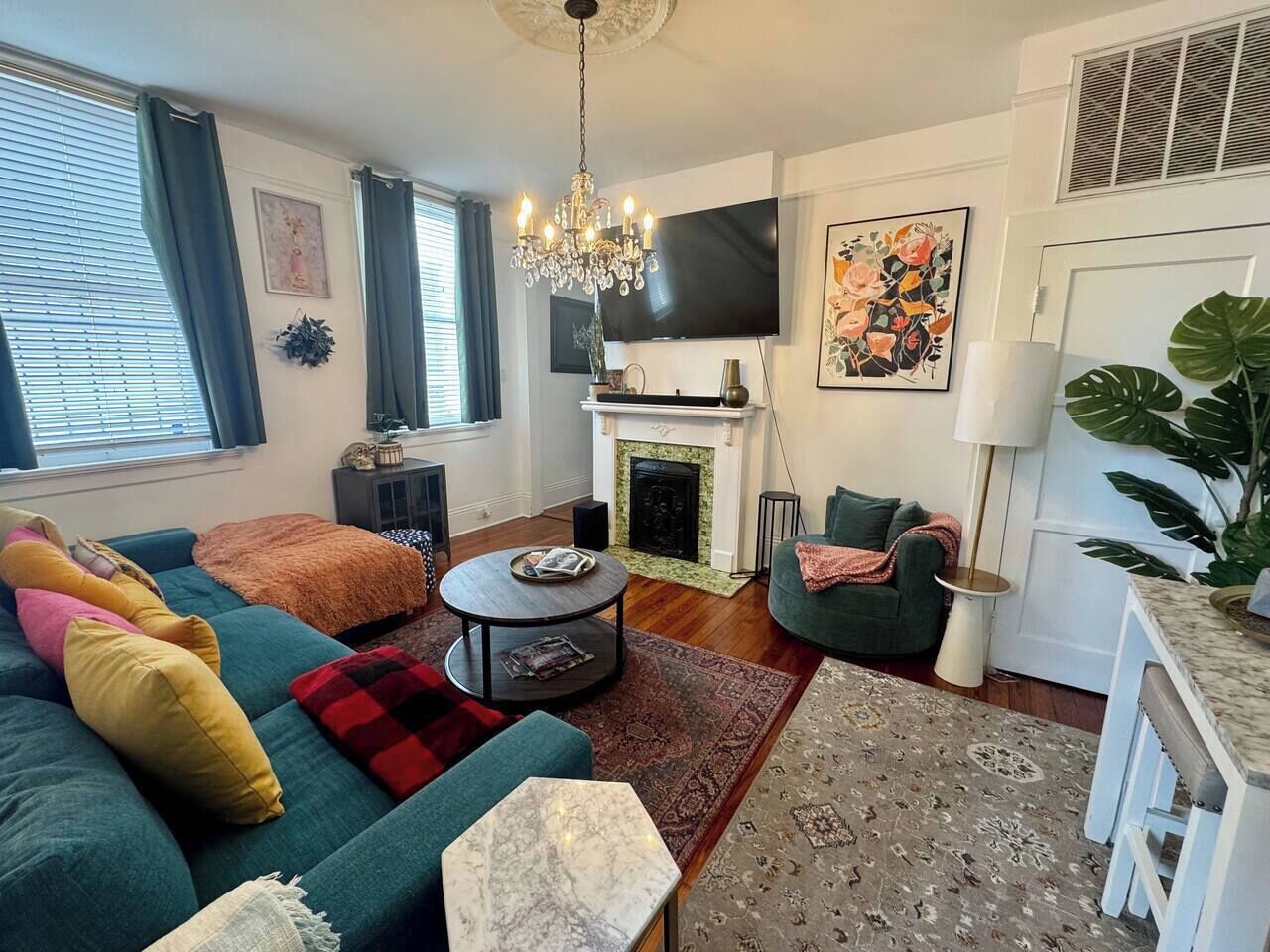 A living room with a sofa, a coffee table, a fireplace, and a television.