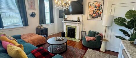 A living room with a sofa, a coffee table, a fireplace, and a television.