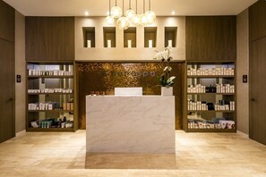 Ein Empfangsbereich mit einer Marmor-Apotheke, Ablagen für Pflegeprodukte und einer Wand mit Mosaikdekor.