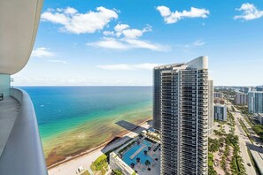 Ein Hochhaus-Hotel mit Pool, Meerblick und städtischer Umgebung.