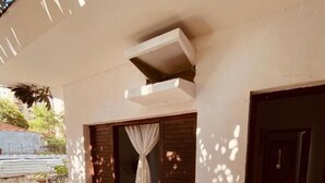 Quarto com varanda, janela com cortinas e porta.