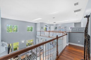 A spacious interior with a wooden staircase, multiple windows, and a view of the outdoors. - 2820 Corey Road (Malabar)