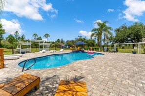 A swimming pool with lounge chairs and a pergola. - 2820 Corey Road (Malabar)