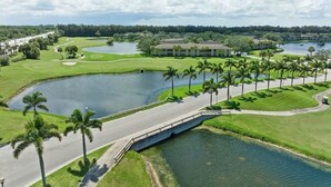 A golf course with multiple ponds, palm trees, and a bridge. - 2820 Corey Road (Malabar)