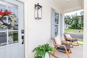 A porch with a wreath, a potted plant, and two rocking chairs. - The Grove Getaway at Patterson Place (Oxford)