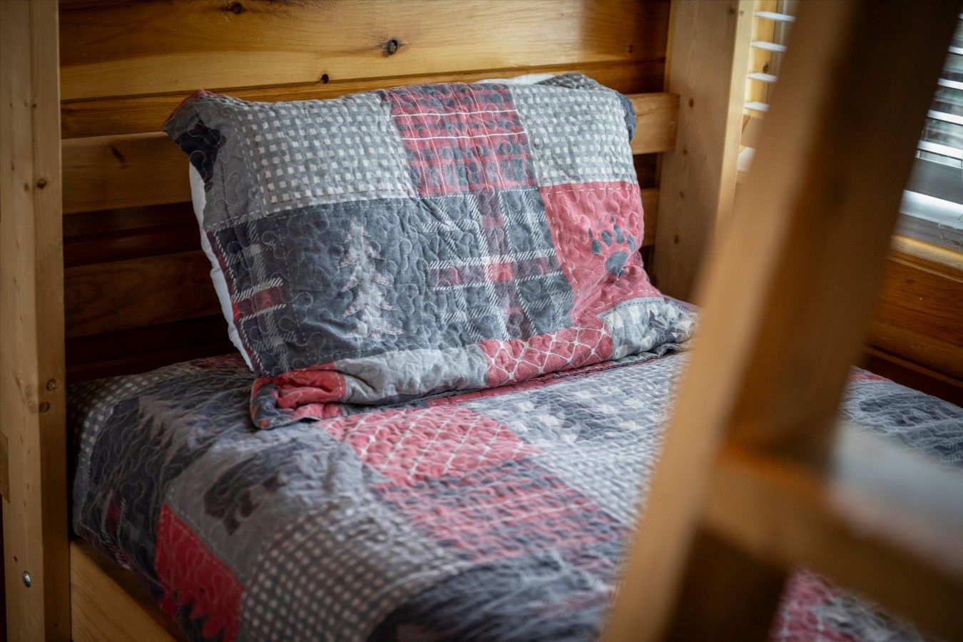 Un lit en bois avec une couvre-lit matelassée et des oreillers.