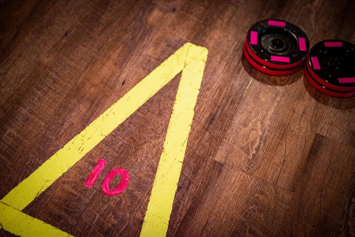 A wooden floor with a yellow directional arrow and the number 10.