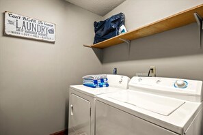 A laundry room with a sign, a stacked laundry basket, and a washing machine. - 5 Mins to Pigeon Forge! Hot Tub*Game Room*Fire Pit (Pigeon Forge)