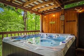 A hot tub in a wooden deck area with a view of green trees. - 5 Mins to Pigeon Forge! Hot Tub*Game Room*Fire Pit (Pigeon Forge)