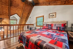 A bedroom with a large bed, a wooden ceiling, a window, and a sign that reads 'CABIN'. - 5 Mins to Pigeon Forge! Hot Tub*Game Room*Fire Pit (Pigeon Forge)
