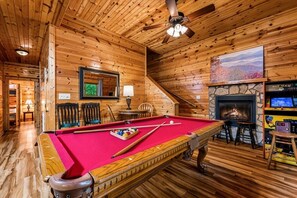 A wooden interior with a pool table, chairs, a fireplace, and a television. - 5 Min to Pigeon Forge! 5BR*Hot Tub*Fire Pit*Quiet (Pigeon Forge)