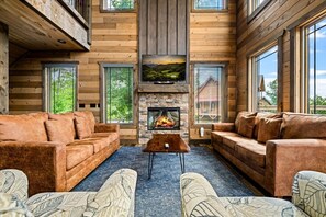 Ein Holzhütten-Interieur mit Kamin, zwei Sofas und einem Couchtisch.