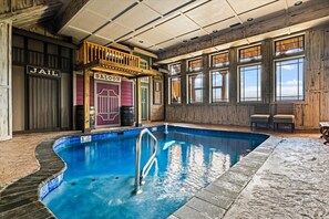 Ein Innenpool mit Holzterrasse und Blick zum Himmel durch große Fenster.