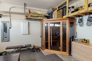 A compact room with a sliding glass door closet, a bench, and a treadmill. - SS Monashee by Okanagan Premier (Beaverdell)